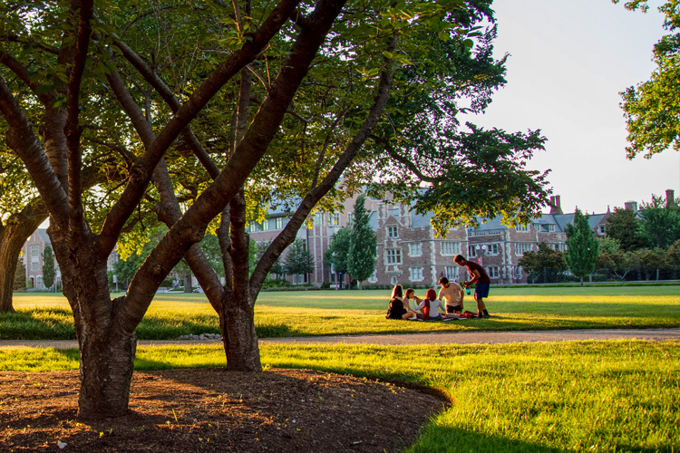 students sitting on ground on campus