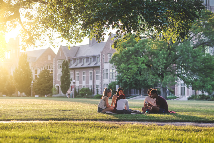 students sitting on ground on campus